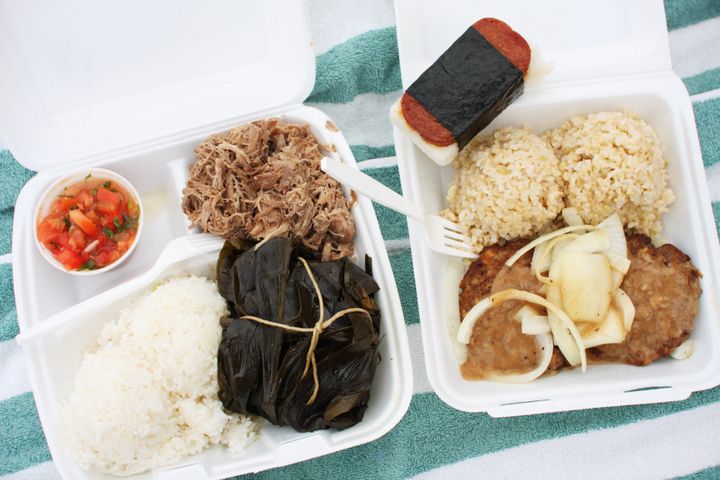 This lunch plate includes Kalua pork and pork lau lau with lomi lomi salmon, loco moco with brown rice and spam musubi.